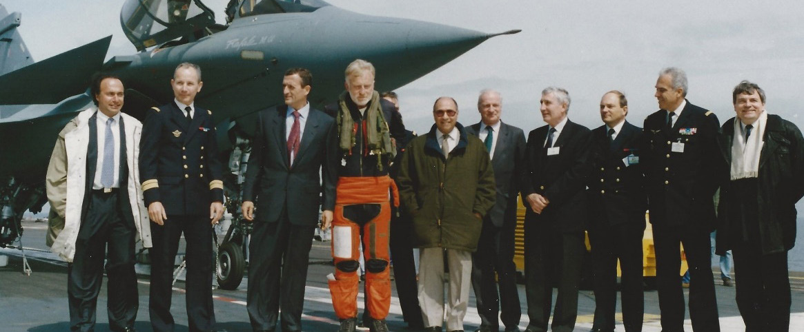 Rafale sur le Foch 1993, journée VIP de la première campagne à la mer : (de g à d) Olivier Dassault, CV Habert (Cdt du Foch), le ministre François Léotard, Yves Kerhervé (1er pilote à apponter un Rafale), masqué Al Coatanea (CEMM), Serge Dassault, Jacques Boyon (Pdt commission défense de l’AN), Yves Sillard (DGA), ICA Besson (DP Rafale), Gal Lanata (CEMAA), Jean-Claude Hironde («père» du Rafale chez Dassault)